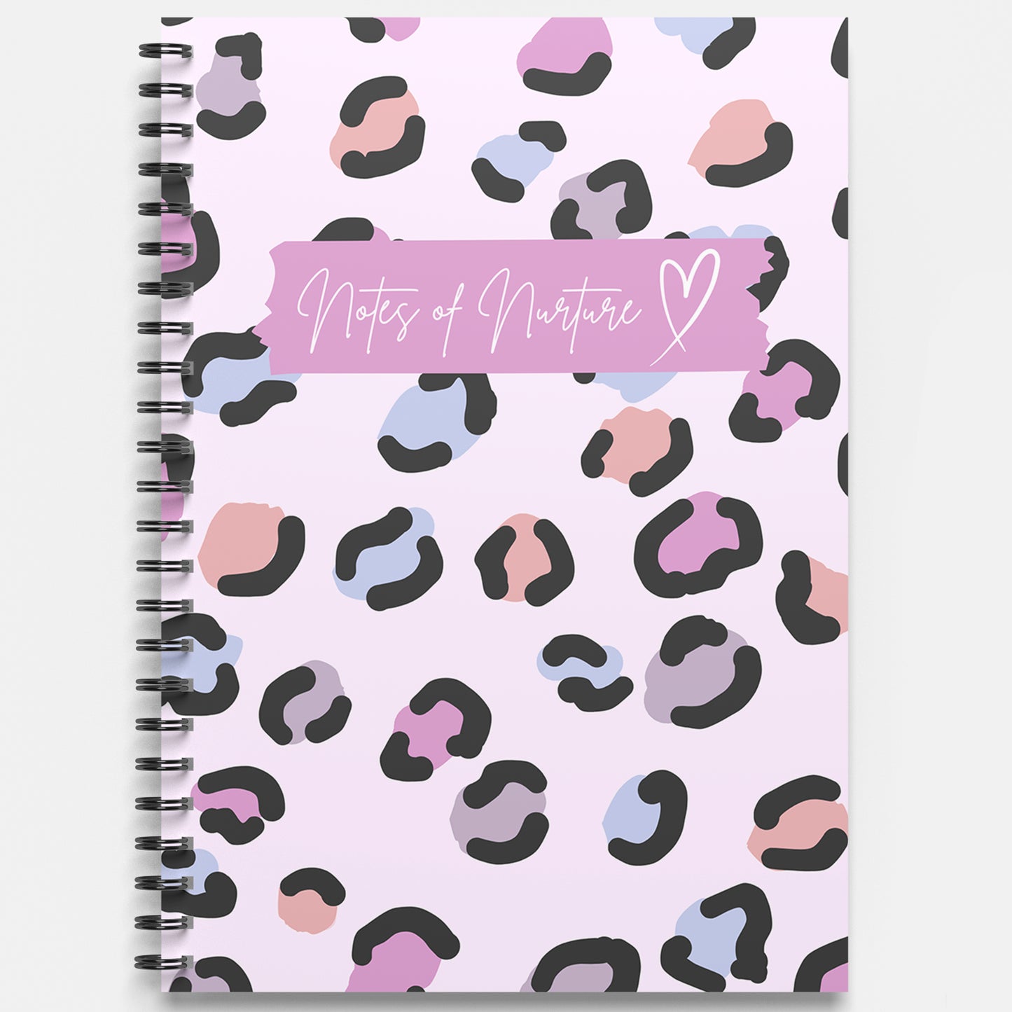 Notebook with colorful leopard print pattern and 'Notes of Nurture' text on a light purple background