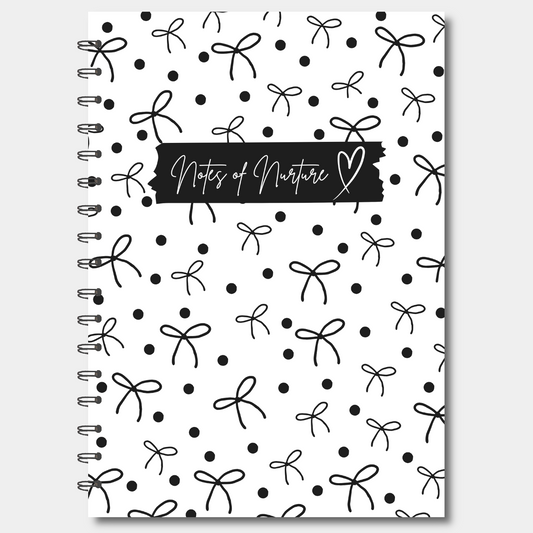 Notebook with black and white bow pattern and 'Notes of Nurture' text on a white background