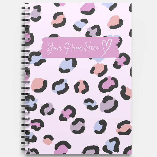 Notebook with colorful leopard print pattern and customizable name space on a pink background