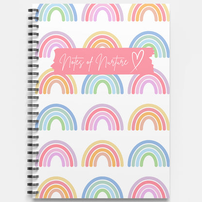 Notebook with rainbow pattern and 'Notes of Nurture' text on a white background