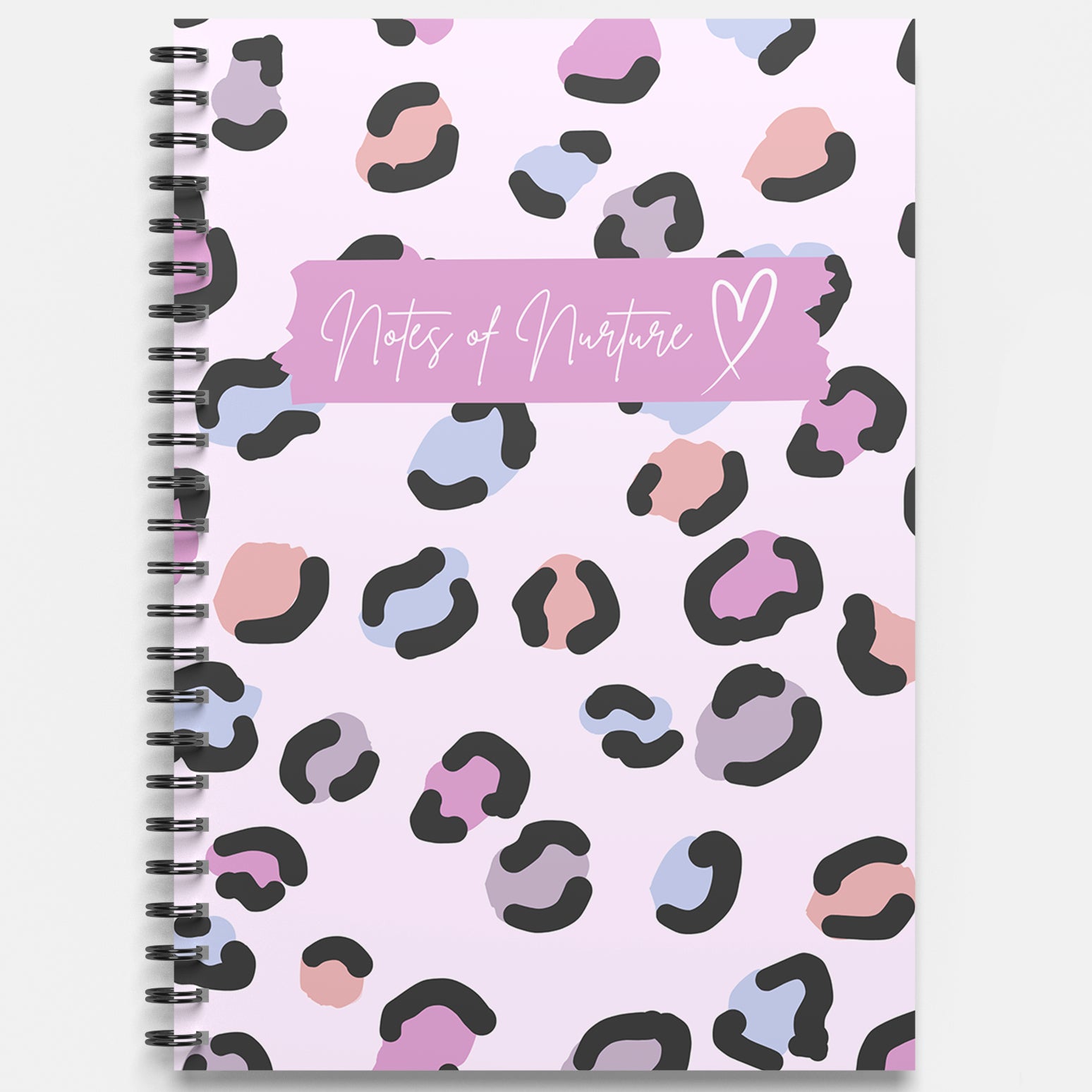 Notebook with colorful leopard print pattern and 'Notes of Nurture' text on a light purple background