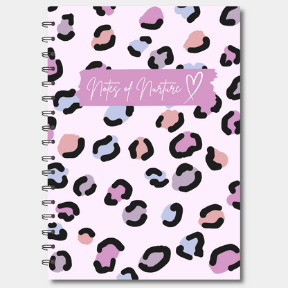 Notebook with pink and black leopard print cover and 'Notes of Nurture' text on a white background